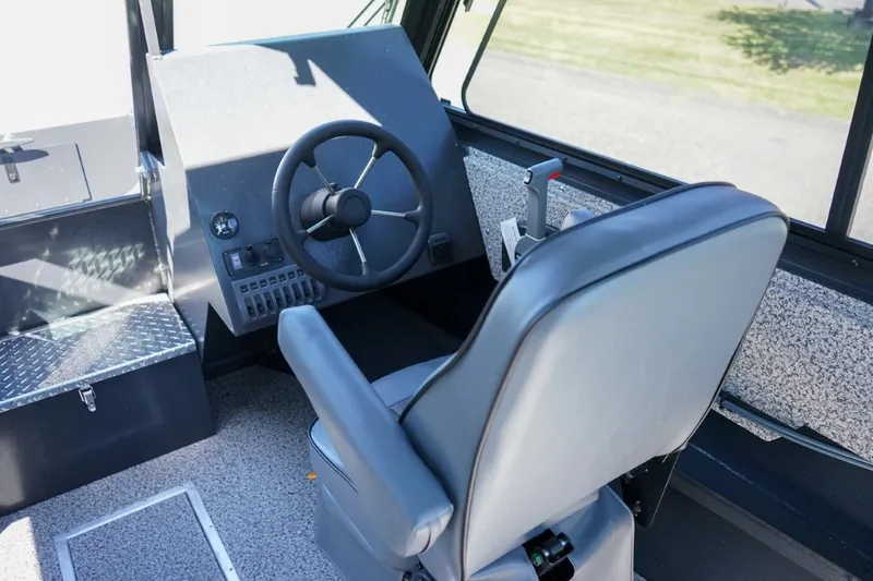 Slide: The Image of 2026 Alumaweld Intruder Outboard 22 boat interior with steering wheel and control panel. - 13