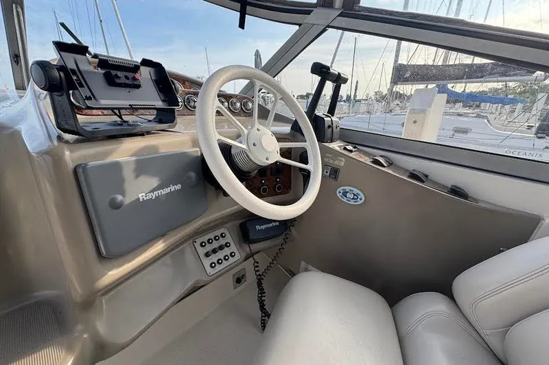 Slide: The Image of Cockpit of 1998 Regal Commodore 292 boat with steering wheel and Raymarine equipment. - 13