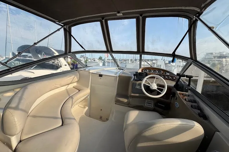 Slide: The Image of Interior of a 1998 Regal Commodore 292 boat with beige seating and steering wheel. - 14