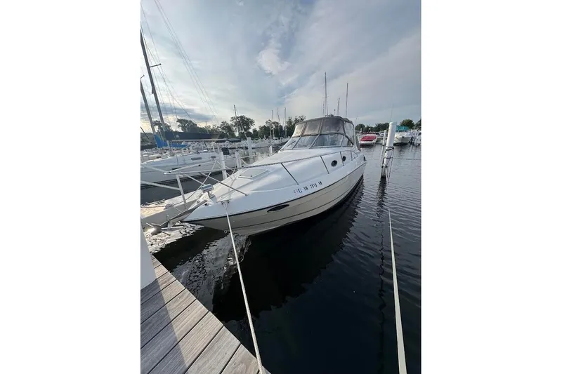 Slide: The Image of 1998 Regal Commodore 292 boat docked at marina, calm water, overcast sky. - 1