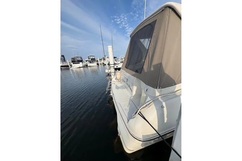 Slide: The Image of 1998 Regal Commodore 292 boat docked in a marina under a clear blue sky. - 4