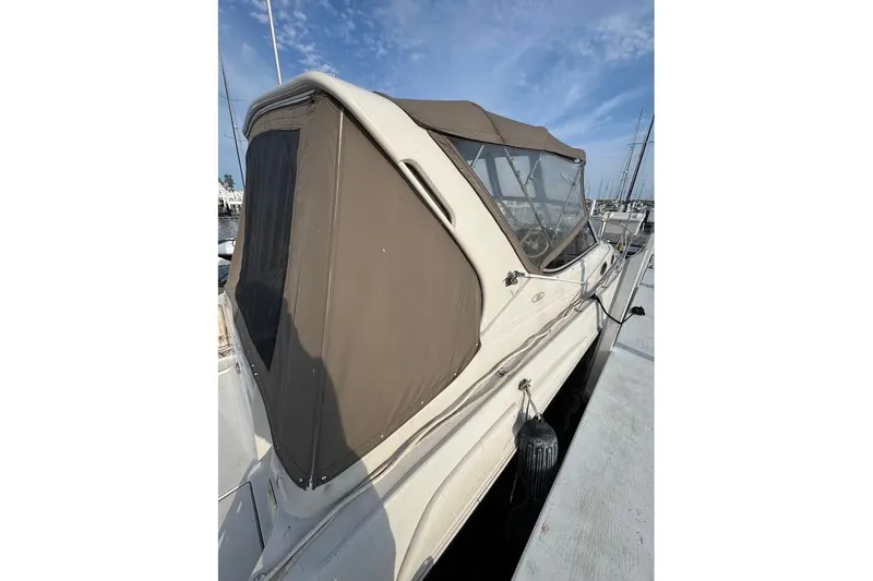 Slide: The Image of 1998 Regal Commodore 292 boat docked, featuring a brown canopy and sleek design. - 5
