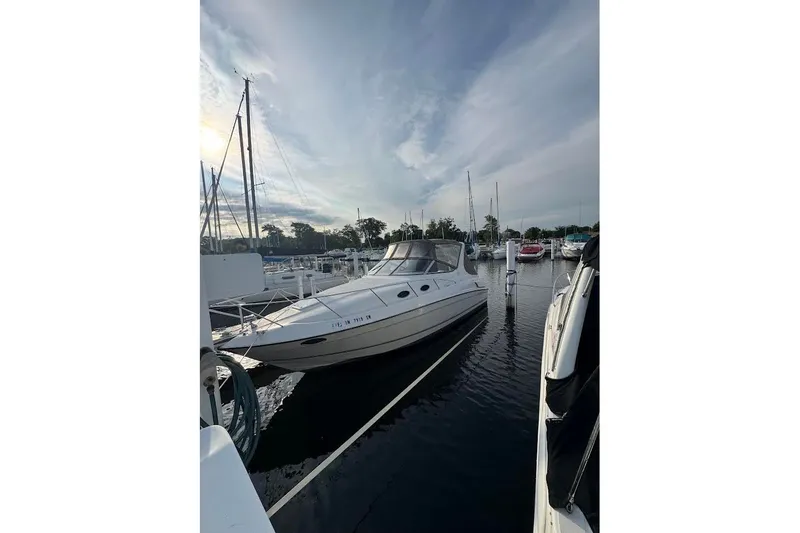 The Image of 1998 Regal Commodore 292 boat docked at marina under cloudy sky. - 0