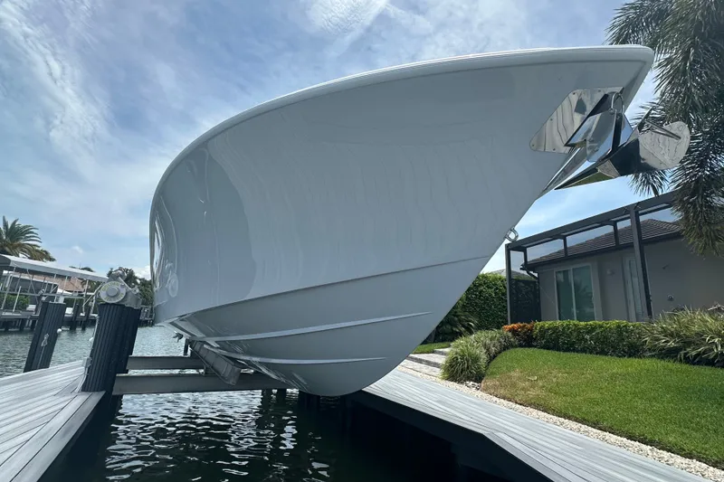 Slide: The Image of 2026 Yellowfin 39 Offshore boat on lift, dockside view with clear sky. - 14