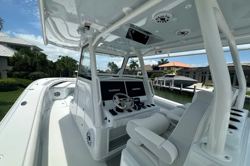 Slide: The Image of 2026 Yellowfin 39 Offshore boat with advanced Garmin navigation system, docked by waterfront homes. - 33