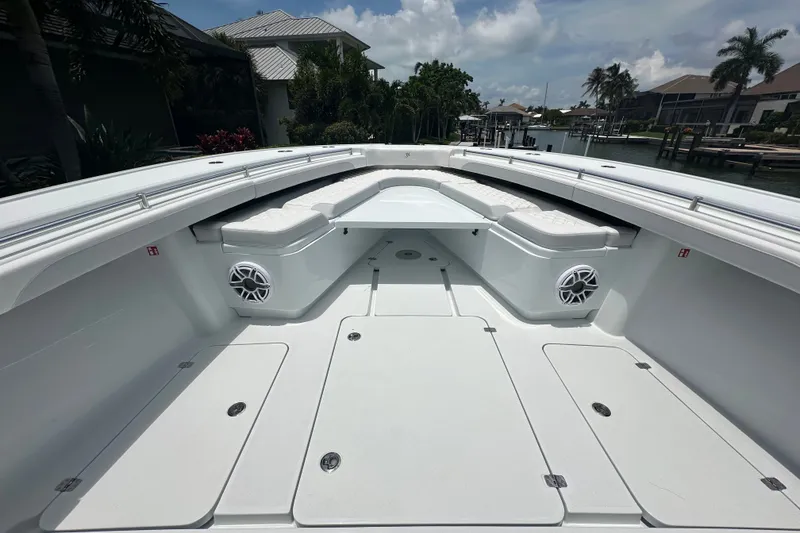 Slide: The Image of 2026 Yellowfin 39 Offshore boat deck with seating and speakers, docked by waterfront homes. - 35