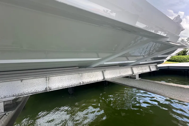 Slide: The Image of 2026 Yellowfin 39 Offshore boat on lift, showcasing sleek hull design above water. - 16