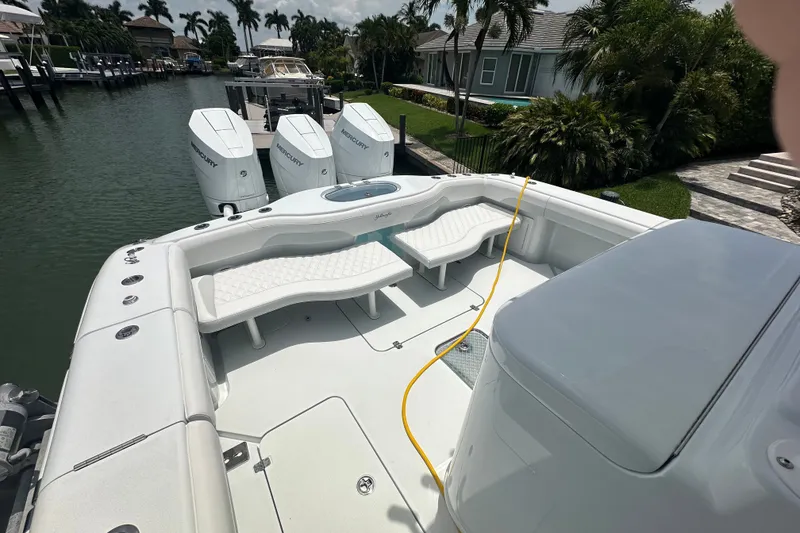 Slide: The Image of 2026 Yellowfin 39 Offshore boat with triple Mercury engines docked by a waterfront property. - 28