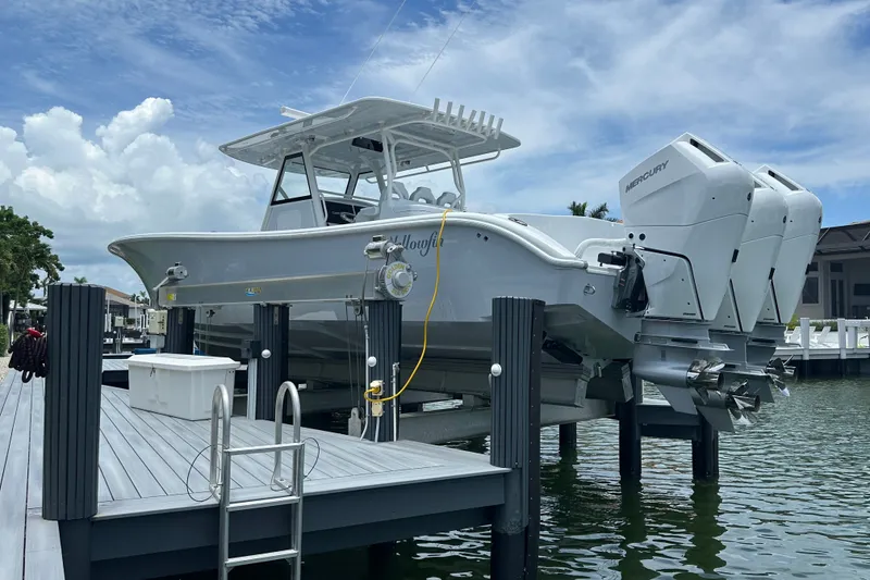 Slide: The Image of 2026 Yellowfin 39 Offshore boat docked with triple Mercury engines, under a clear sky. - 8
