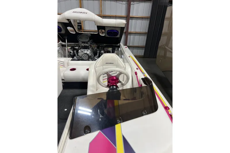 Slide: The Image of 1999 Shockwave 21LS boat interior with steering wheel, engine, and colorful accents. - 9