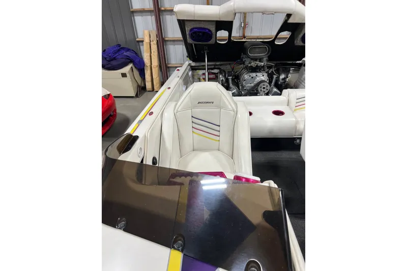 Slide: The Image of 1999 Shockwave 21LS boat interior with white seating and visible engine. - 8