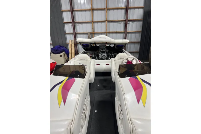 Slide: The Image of 1999 Shockwave 21LS boat interior with colorful upholstery and visible engine in storage. - 6