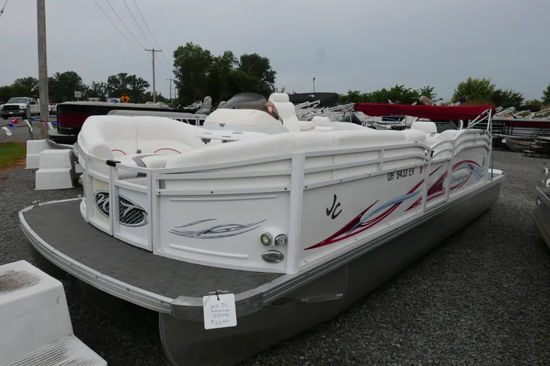 Slide: The Image of 2011 JC 23 SunLounger TT pontoon boat with white seating and decorative graphics. - 1
