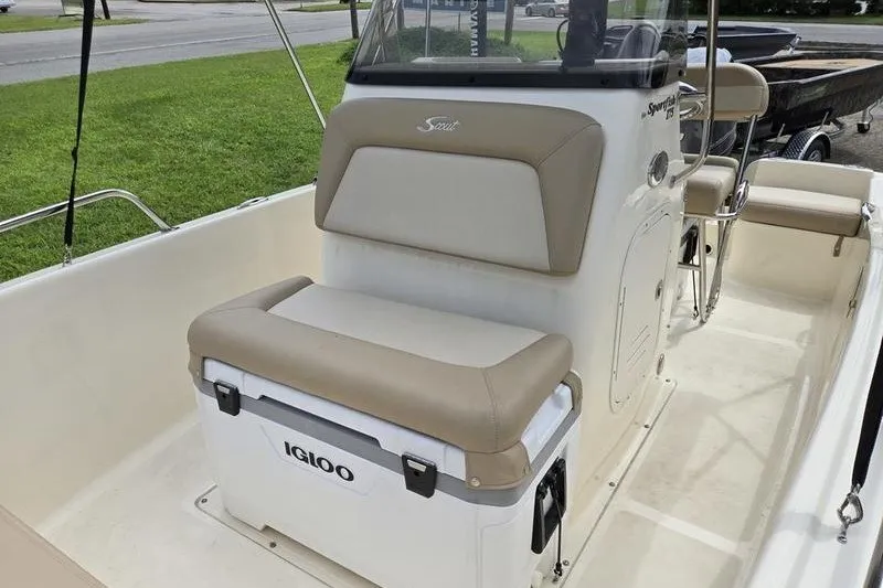 Slide: The Image of 2025 Scout 175 Sportfish boat interior with Igloo cooler and cushioned seating. - 4
