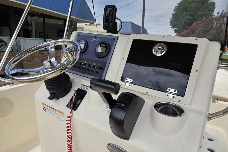 Slide: The Image of 2025 Scout 175 Sportfish boat console with steering wheel, controls, and gauges. - 16