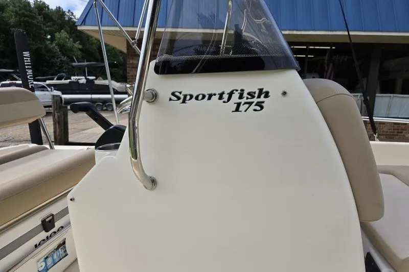 Slide: The Image of 2025 Scout 175 Sportfish boat console with seating, docked outdoors. - 13