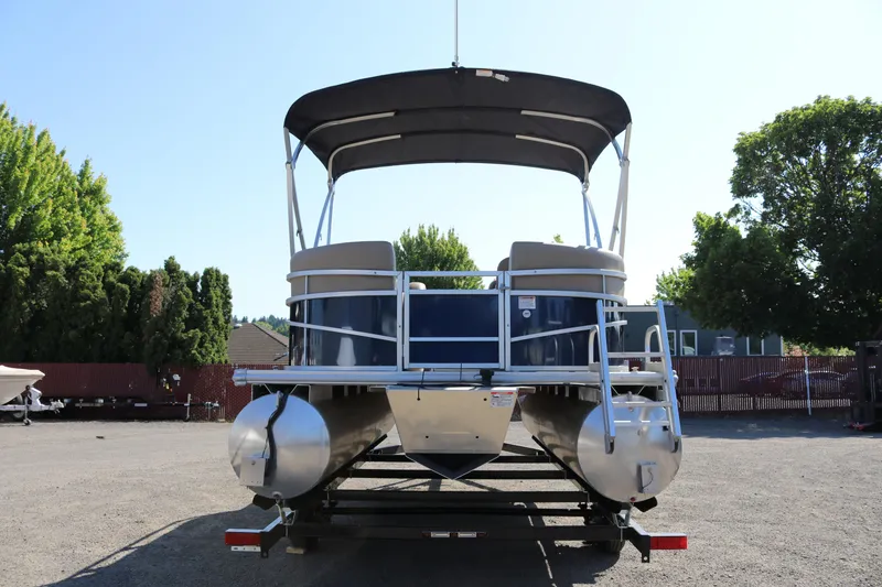 Slide: The Image of 2025 Sun Chaser Vista Fish 18 pontoon boat with canopy, parked outdoors. - 3