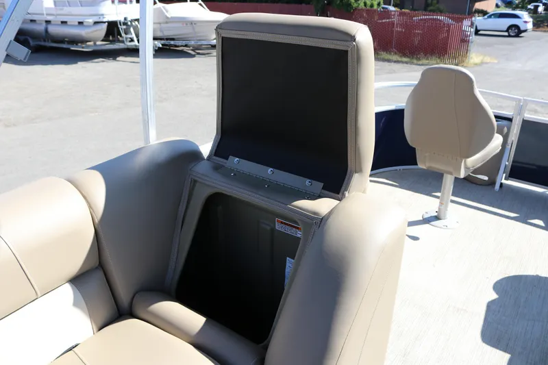 Slide: The Image of 2025 Sun Chaser Vista Fish 18 boat with open storage compartment and beige seating. - 16
