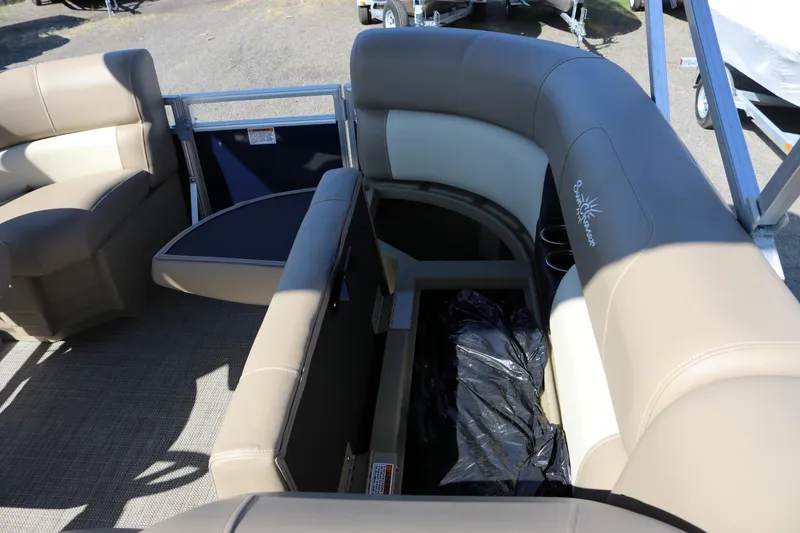 Slide: The Image of 2025 Sun Chaser Vista Fish 18 pontoon boat interior with beige seating and storage compartment. - 17