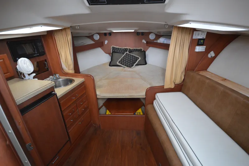 Slide: The Image of 2004 Luhrs 320 Open cabin interior with kitchenette, bed, and seating area. - 19