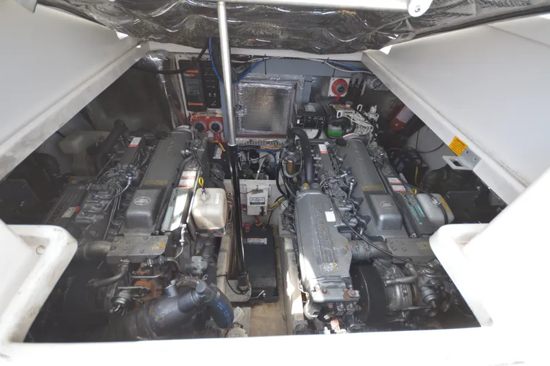Slide: The Image of Engine compartment of 2004 Luhrs 320 Open boat, showcasing dual engines and mechanical components. - 24
