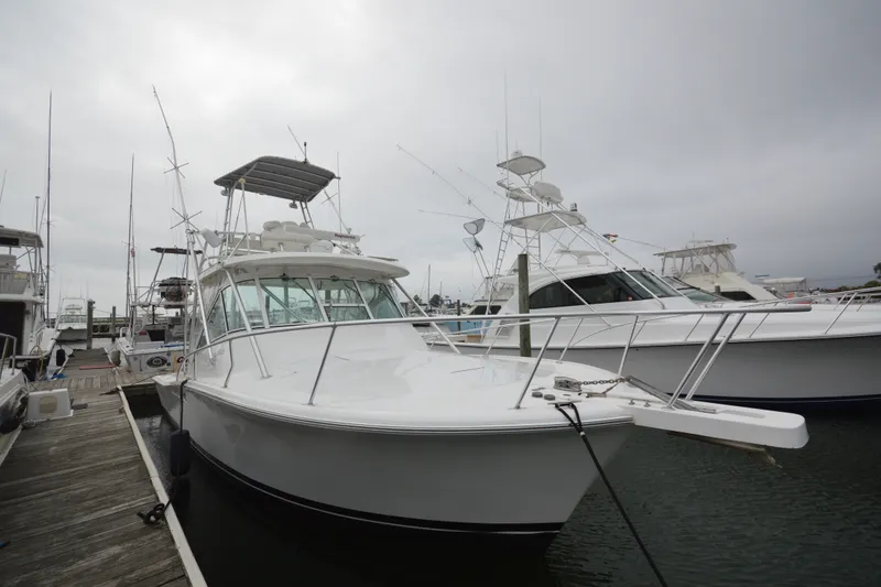Slide: The Image of 2004 Luhrs 320 Open boat docked at marina under cloudy sky. - 4