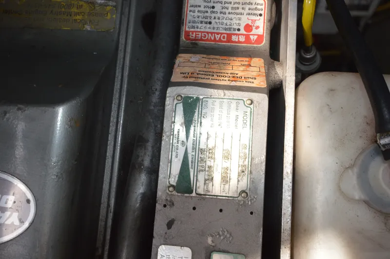 Slide: The Image of Engine compartment of a 2004 Luhrs 320 Open boat, showing warning labels and engine specifications. - 31