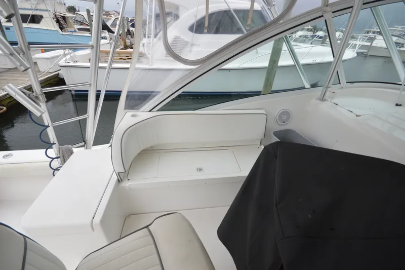 Slide: The Image of 2004 Luhrs 320 Open boat interior with seating and docked vessels in background. - 10