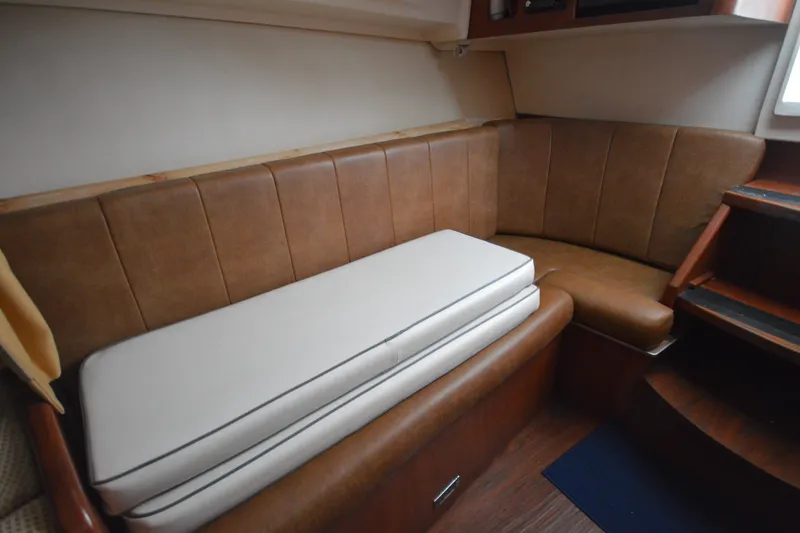 Slide: The Image of 2004 Luhrs 320 Open cabin interior with brown leather seating and white cushions. - 23