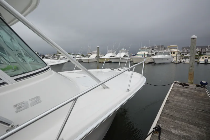 Slide: The Image of 2004 Luhrs 320 Open boat docked at a marina under cloudy skies. - 6