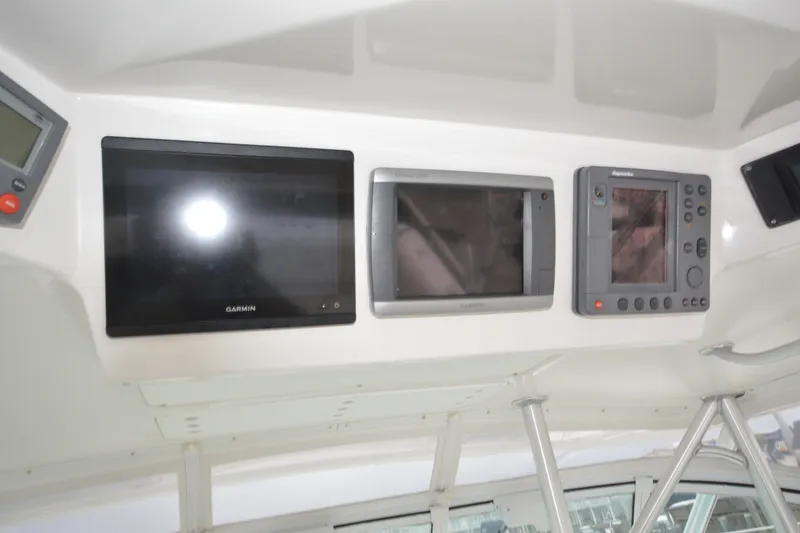 Slide: The Image of 2004 Luhrs 320 Open boat dashboard with Garmin and Raymarine navigation displays. - 15