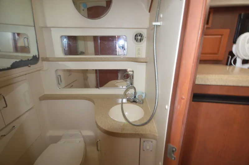 Slide: The Image of 2004 Luhrs 320 Open yacht bathroom with sink, mirror, and storage cabinets. - 22