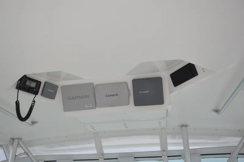 Slide: The Image of Ceiling electronics on a 2004 Luhrs 320 Open boat, featuring Garmin and Raymarine devices. - 7
