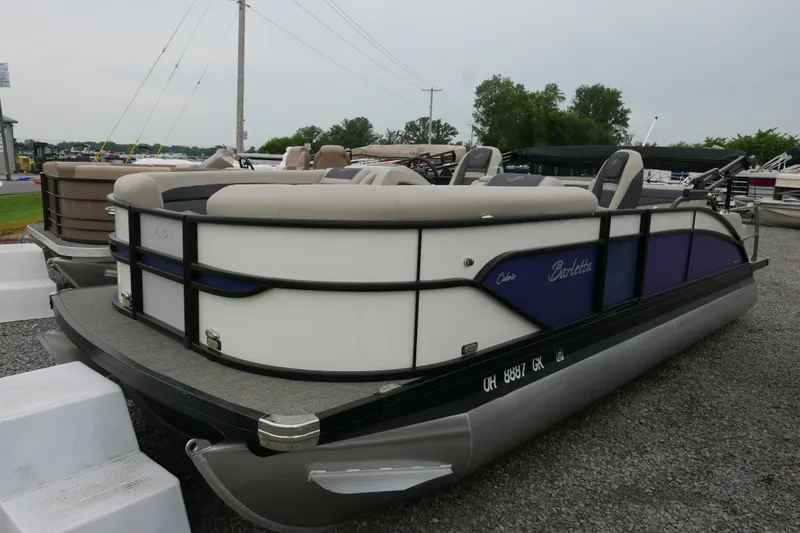 The Image of 2023 Barletta Cabrio C22UC pontoon boat with sleek design, parked on gravel. - 0