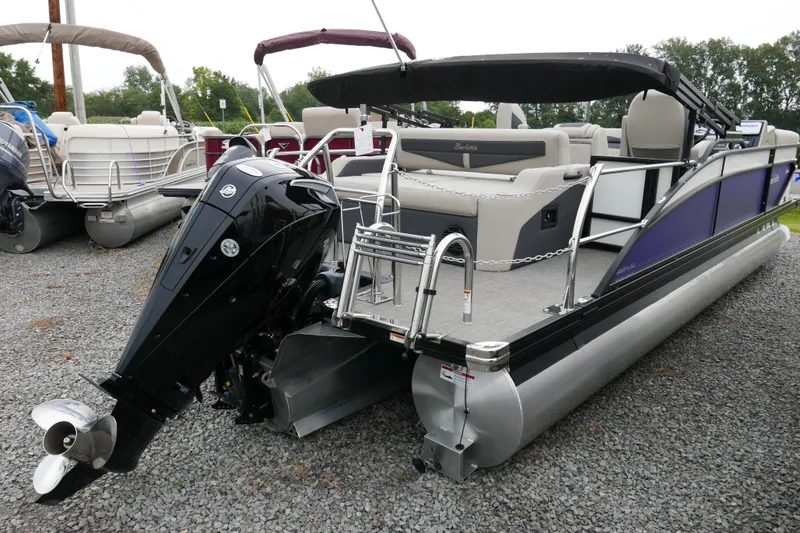 Slide: The Image of 2023 Barletta Cabrio C22UC pontoon boat with outboard motor, parked on gravel. - 3