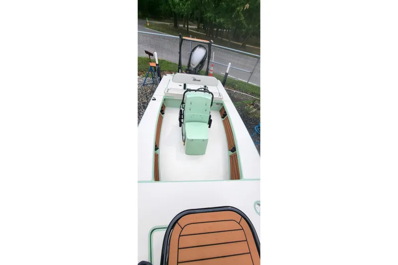 Slide: The Image of 2019 Maverick Mirage 18 HPX-V boat with green accents, parked outdoors. - 14