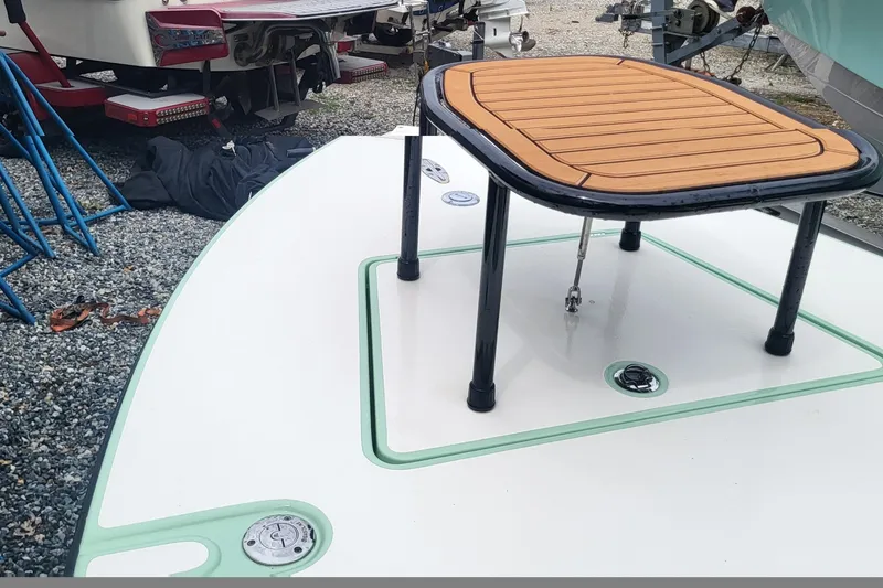 Slide: The Image of 2019 Maverick Mirage 18 HPX-V boat deck with elevated platform, parked on gravel. - 12