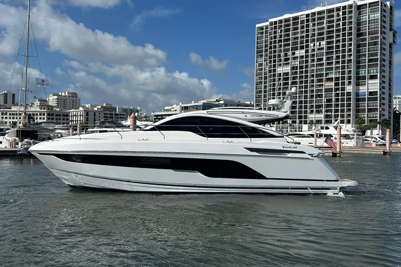 The Image of 2026 Fairline Targa 47 GT yacht docked in a marina with cityscape background. - 0