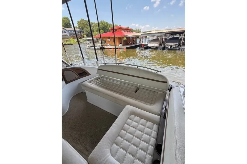 Slide: The Image of 2018 Cobalt R5 boat interior with cushioned seating, docked near waterfront homes. - 9