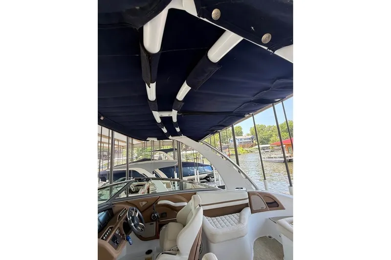 Slide: The Image of 2018 Cobalt R5 boat interior with canopy, docked by a scenic waterfront. - 3