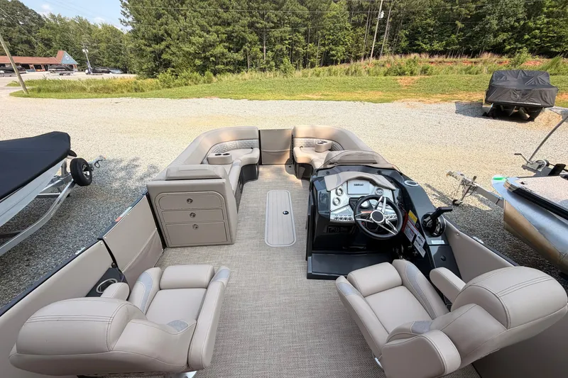 Slide: The Image of 2023 Crest Carribbean 250 SLC pontoon boat interior with plush seating and modern dashboard. - 7