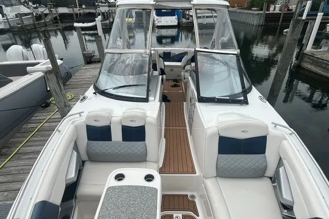 Slide: The Image of 2013 Chaparral 327 SSX boat docked, featuring spacious seating and sleek design. - 7