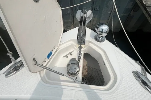 Slide: The Image of 2013 Chaparral 327 SSX boat anchor compartment with open hatch and chain mechanism. - 8