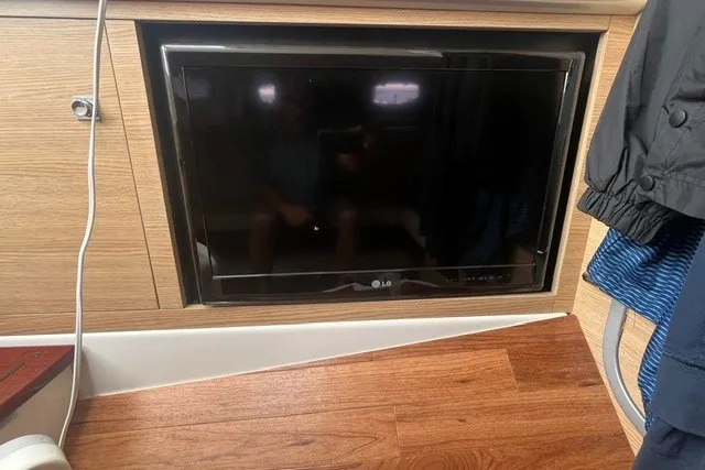 Slide: The Image of LG TV installed in a 2013 Chaparral 327 SSX boat interior with wood paneling. - 33