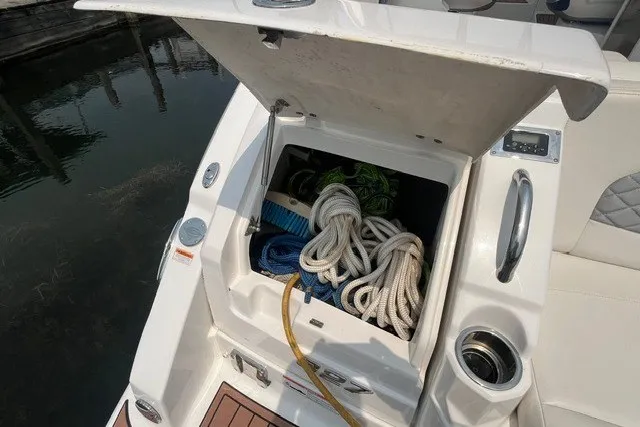 Slide: The Image of 2013 Chaparral 327 SSX boat storage compartment with ropes and cleaning supplies. - 35