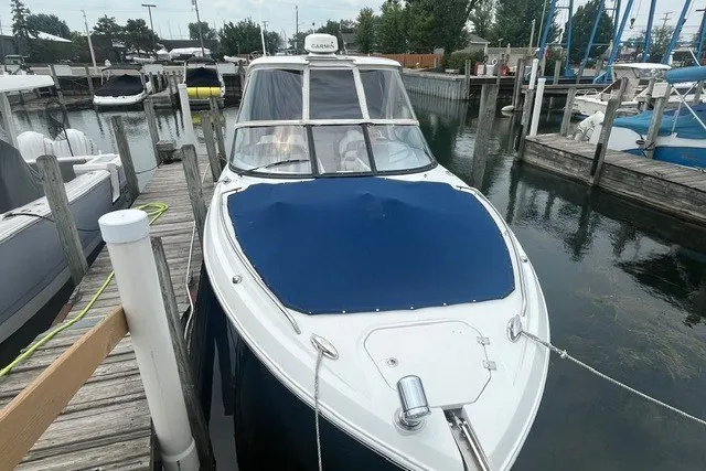 Slide: The Image of 2013 Chaparral 327 SSX boat docked at marina, covered with blue tarp. - 4