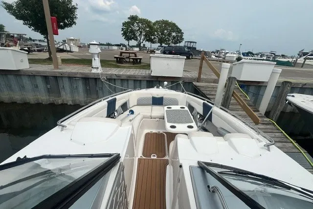 Slide: The Image of 2013 Chaparral 327 SSX boat docked, featuring spacious seating and a wooden deck. - 10