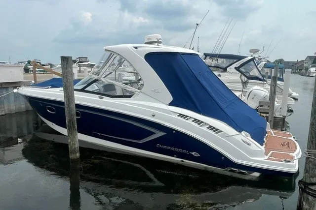 Slide: The Image of 2013 Chaparral 327 SSX boat docked with blue cover in marina. - 3