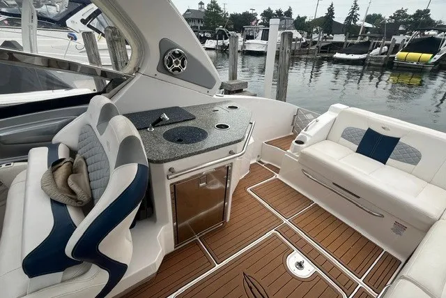 Slide: The Image of 2013 Chaparral 327 SSX boat interior with seating and kitchenette by the dock. - 20