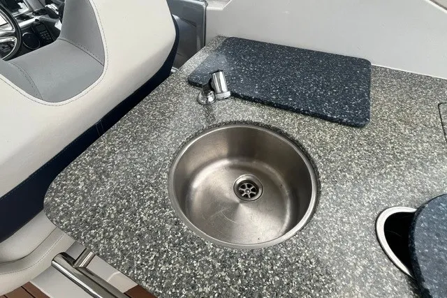 Slide: The Image of ```json "2013 Chaparral 327 SSX boat interior with granite countertop and stainless steel sink." ``` - 27